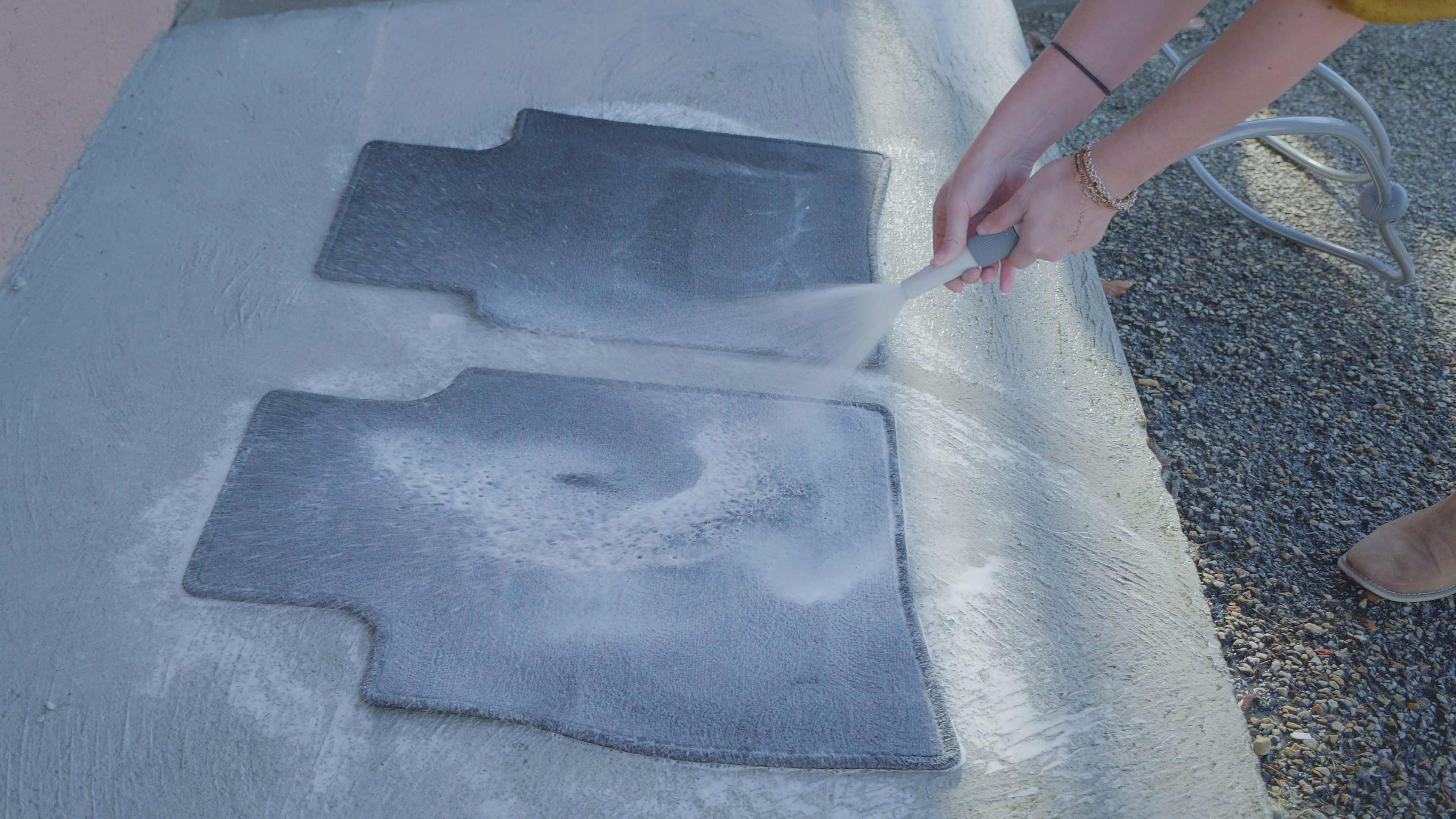 Rin&ccedil;age des tapis de voiture au jet d'eau